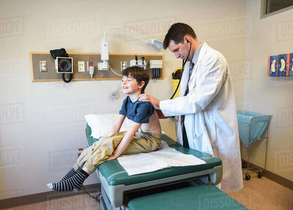 Doctor With Stethoscope On Young Child s Back On A Clinic 